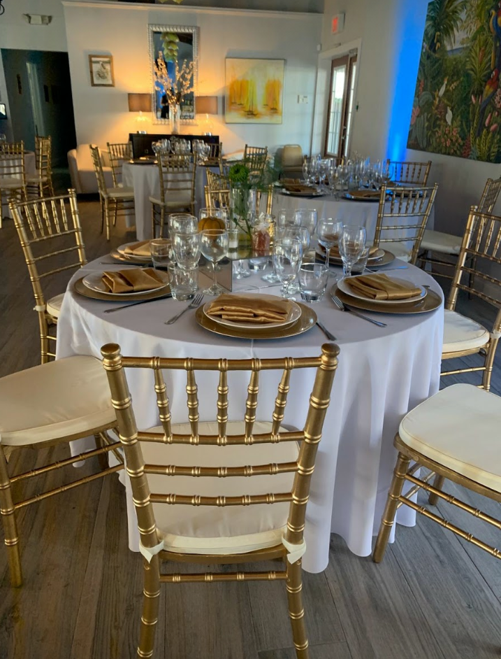 gold Chiavari chairs and white linen rentals for indoor wedding